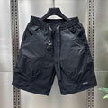 Black cargo shorts with a slightly shiny material and black drawstring.