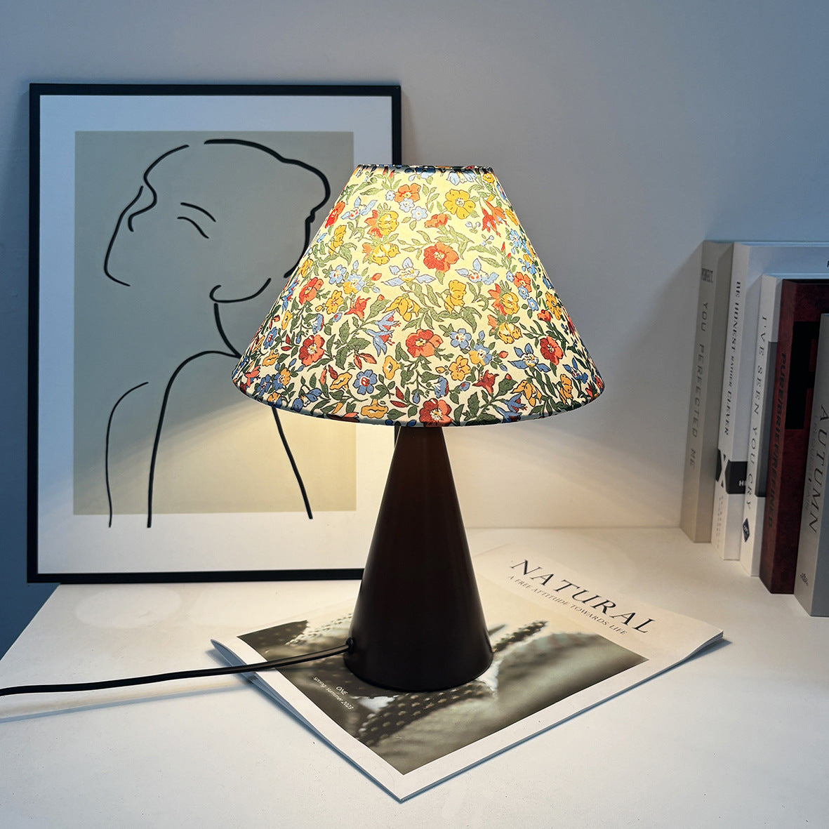 Vintage medieval table lamp featuring colorful floral print shade and dark metal base displayed on a white surface.