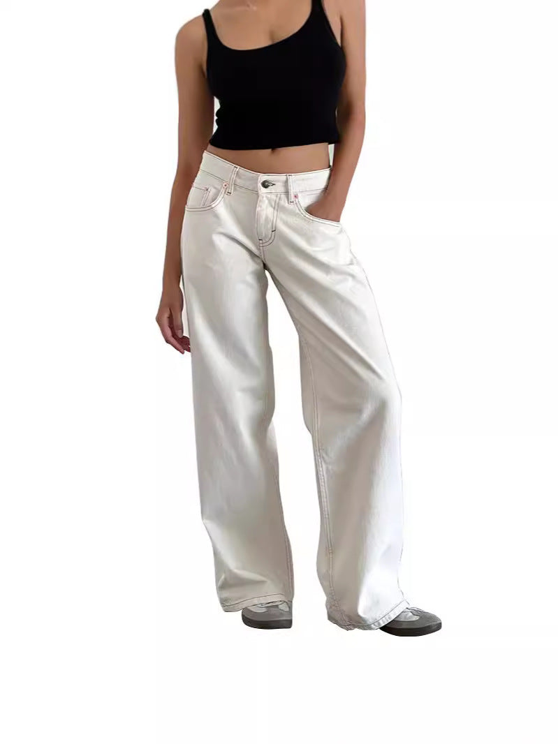Woman wearing high-waisted white straight-leg wide jeans with a black crop top, standing with one hand in pocket, front view.