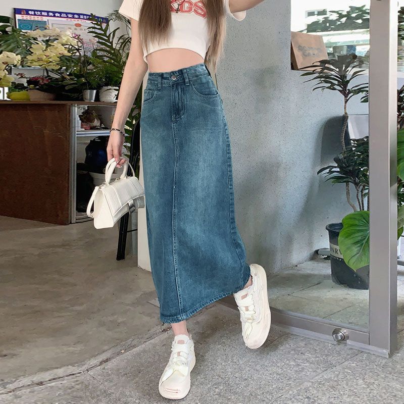 Long denim skirt in vintage blue, side view showing hip-hugging fit and retro wash