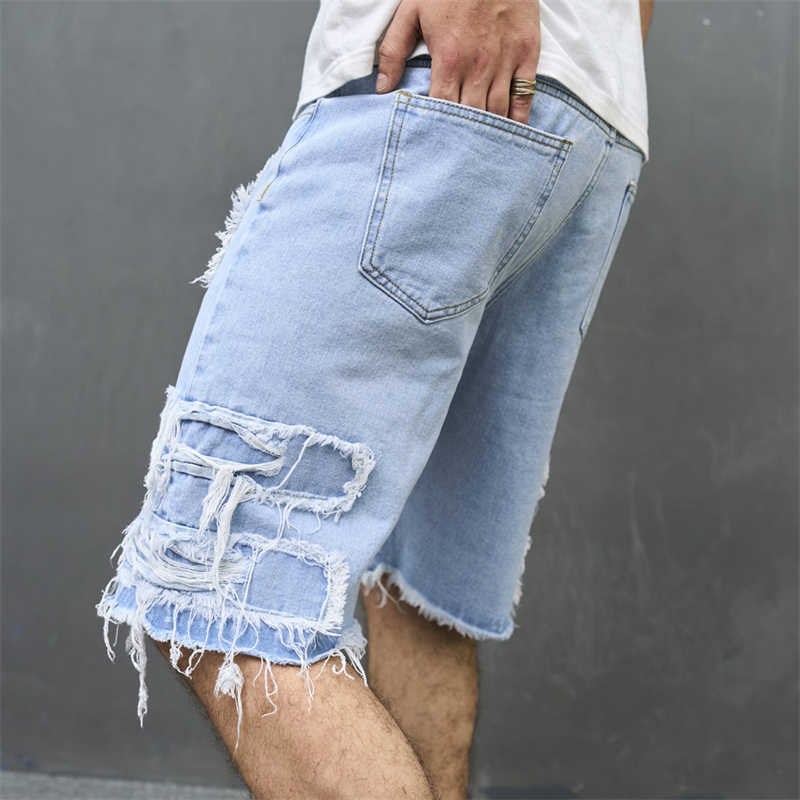 Close-up of distressed cat's whisker fading on baggy denim shorts