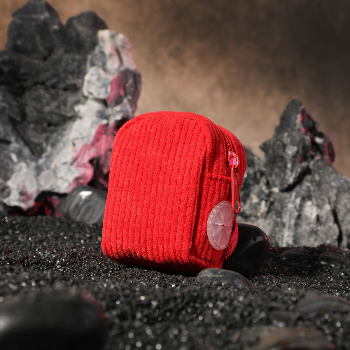 Red corduroy dog poop bag holder, small standing pouch with ribbed fabric on black stones