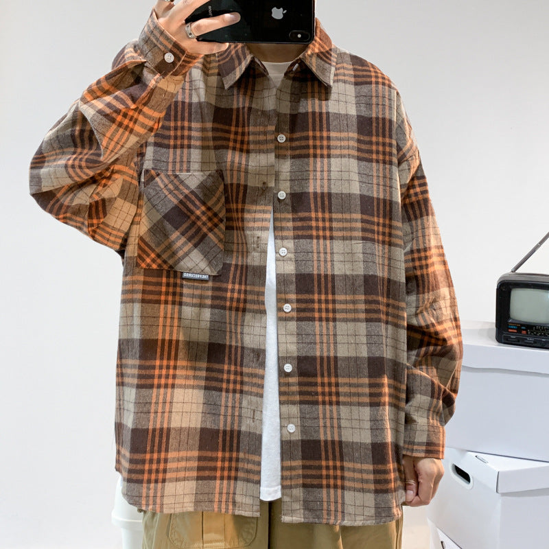 Men's khaki, orange and brown plaid flannel shacket worn open over a white tee