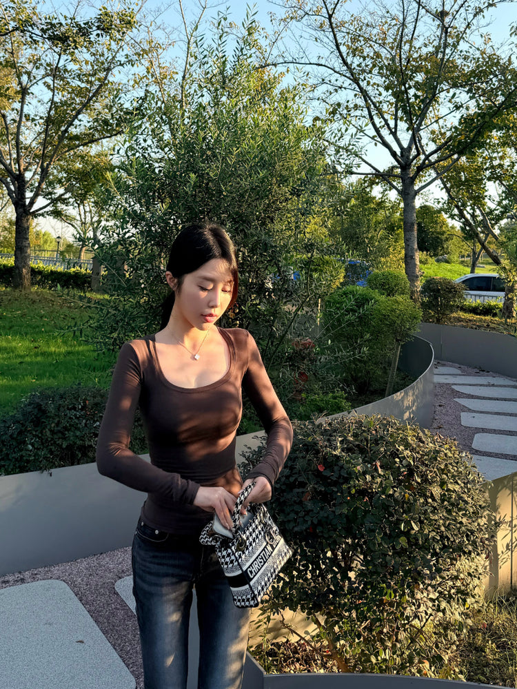Woman wearing slim fit sheer black long sleeve cotton spandex top outdoors in park, full outfit lifestyle shot