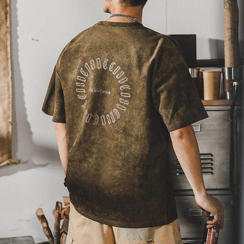 Olive green suede T-shirt back view showing large distressed ECHHERE circular print, oversized fit on male model in casual streetwear pose