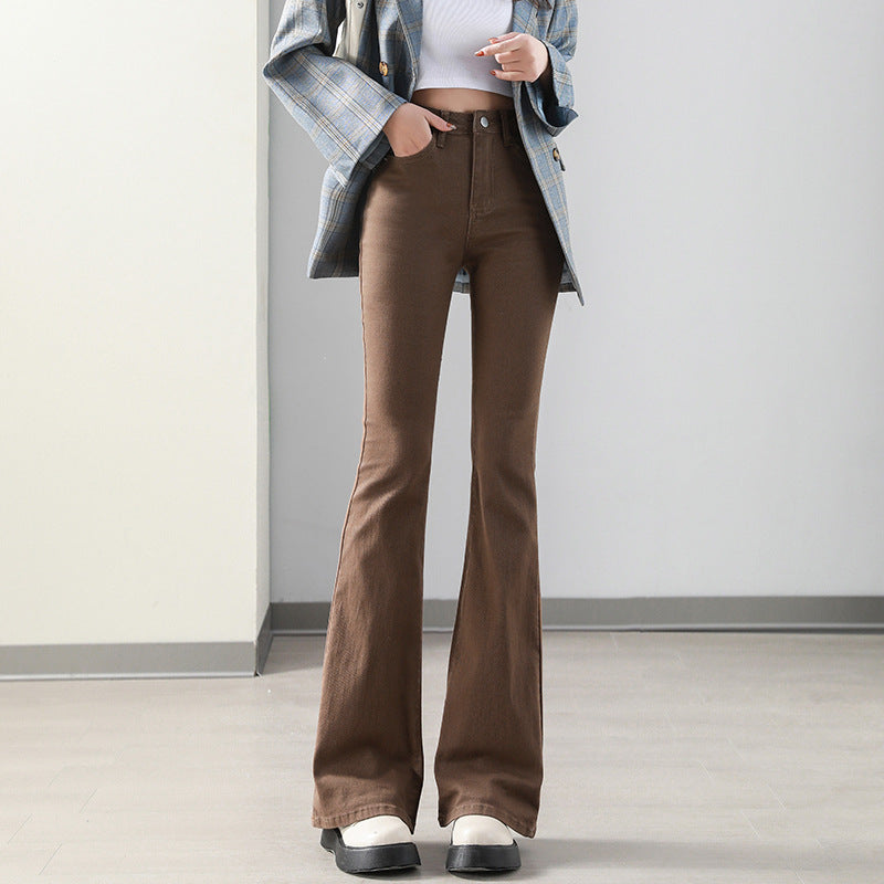 Person wearing brown flared jeans with a plain background