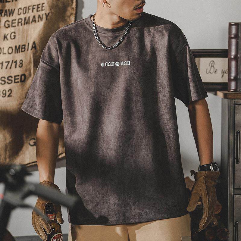 Warm olive suede T-shirt on young man, soft brushed interior, relaxed fit, indoor gym-style setting with prop
