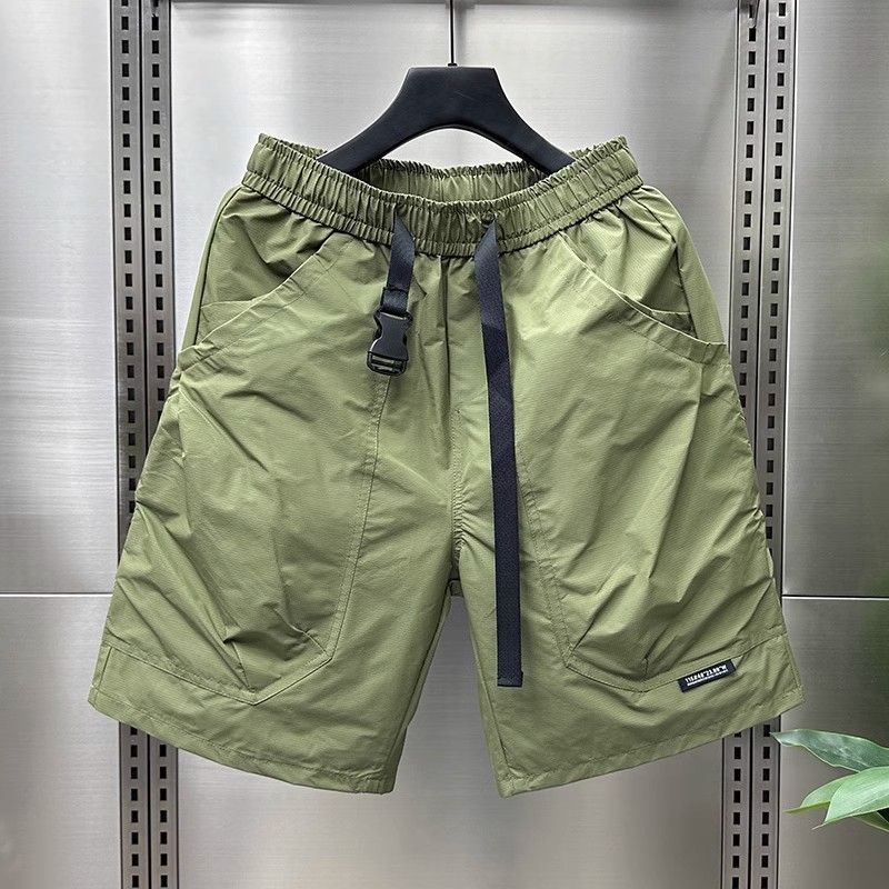 Light olive green cargo shorts with multiple pockets and drawstring waist