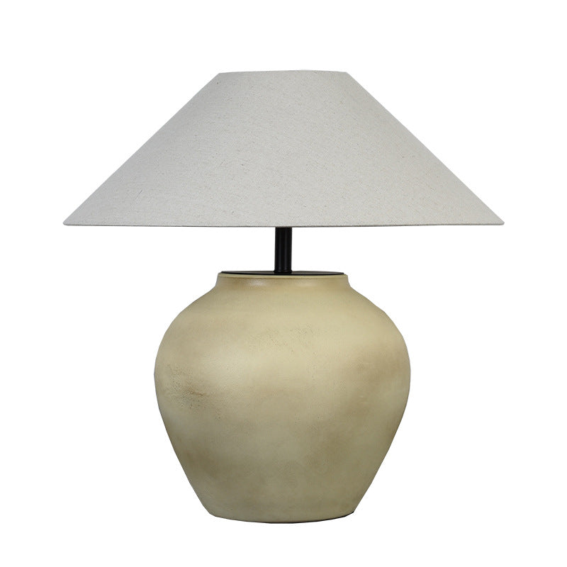 Side view of beige vintage Japanese retro ceramic table lamp with rounded base and fabric shade, tabletop design.