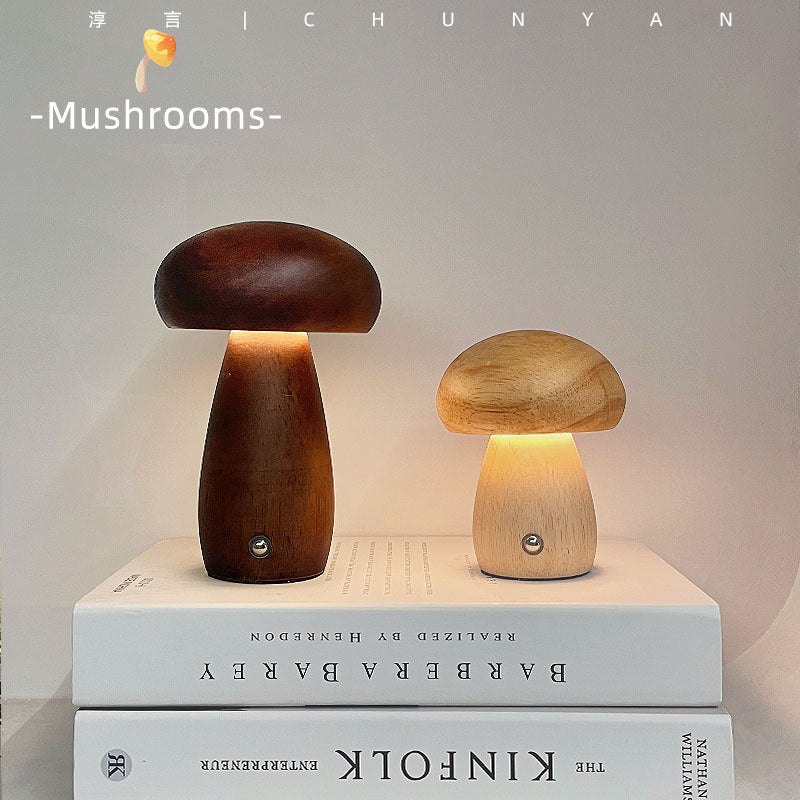 Dark walnut wooden mushroom lamp and smaller light wood version placed on stacked books