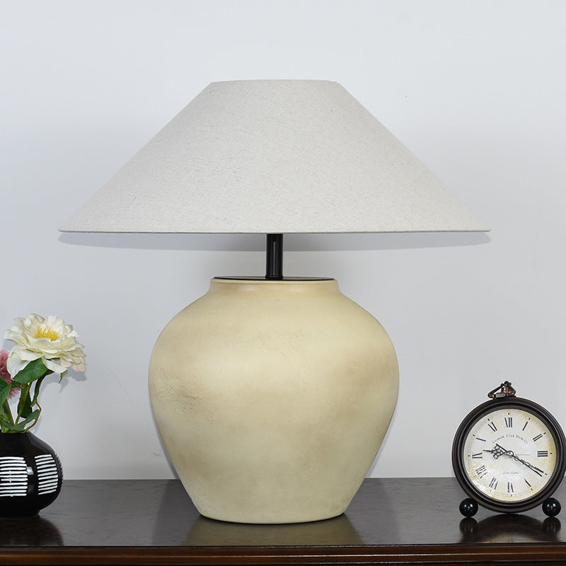 Beige vintage Japanese retro ceramic tabletop lamp with fabric shade, displayed on dark surface beside clock and flowers.