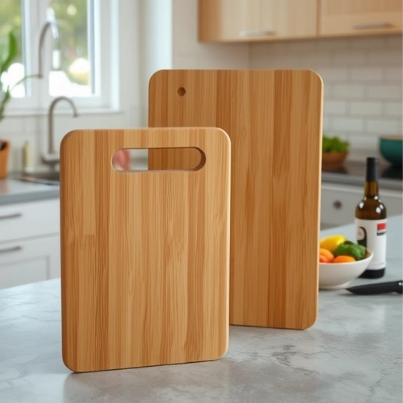 A single medium-sized bamboo cutting board with a handle, standing upright in a modern kitchen setting with wooden cabinets and a countertop visible in the background.