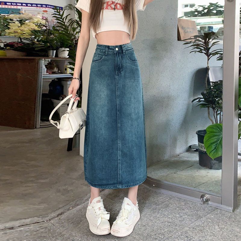 Women's high waisted a-line denim maxi skirt in vintage blue, front view with crop top and sneakers
