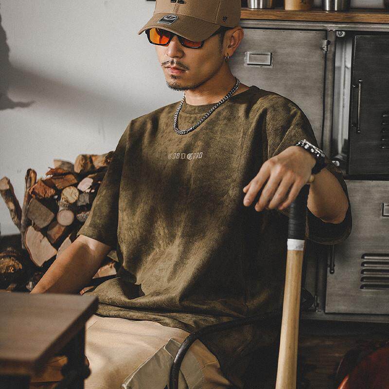 Men’s olive suede T-shirt front view, soft velvety fabric with subtle ECHHERE chest print, relaxed oversized crewneck on young model with chain necklace 