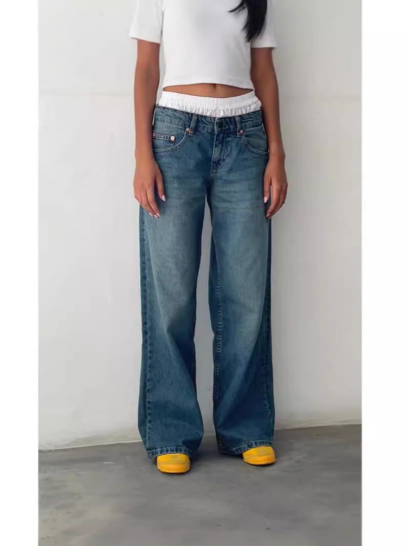 Woman in medium-wash blue high-waisted straight-leg wide jeans with yellow shoes and white top, front view.
