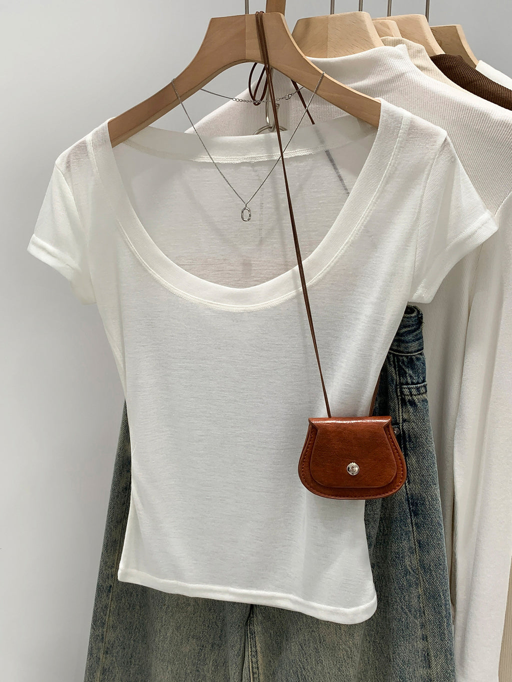 Off-white women's scoop neck t-shirt, front view on hanger