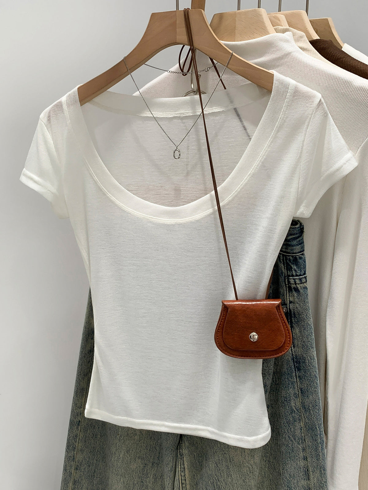 Off-white women's scoop neck t-shirt, front view on hanger