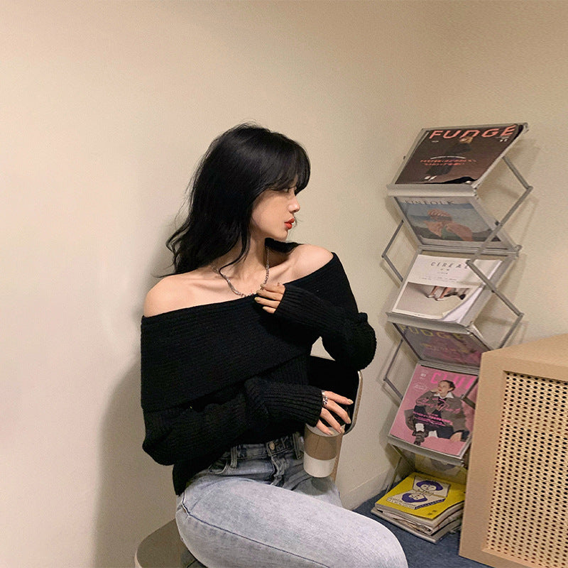 Black off shoulder ribbed knit sweater with wide neckline worn with light wash jeans
