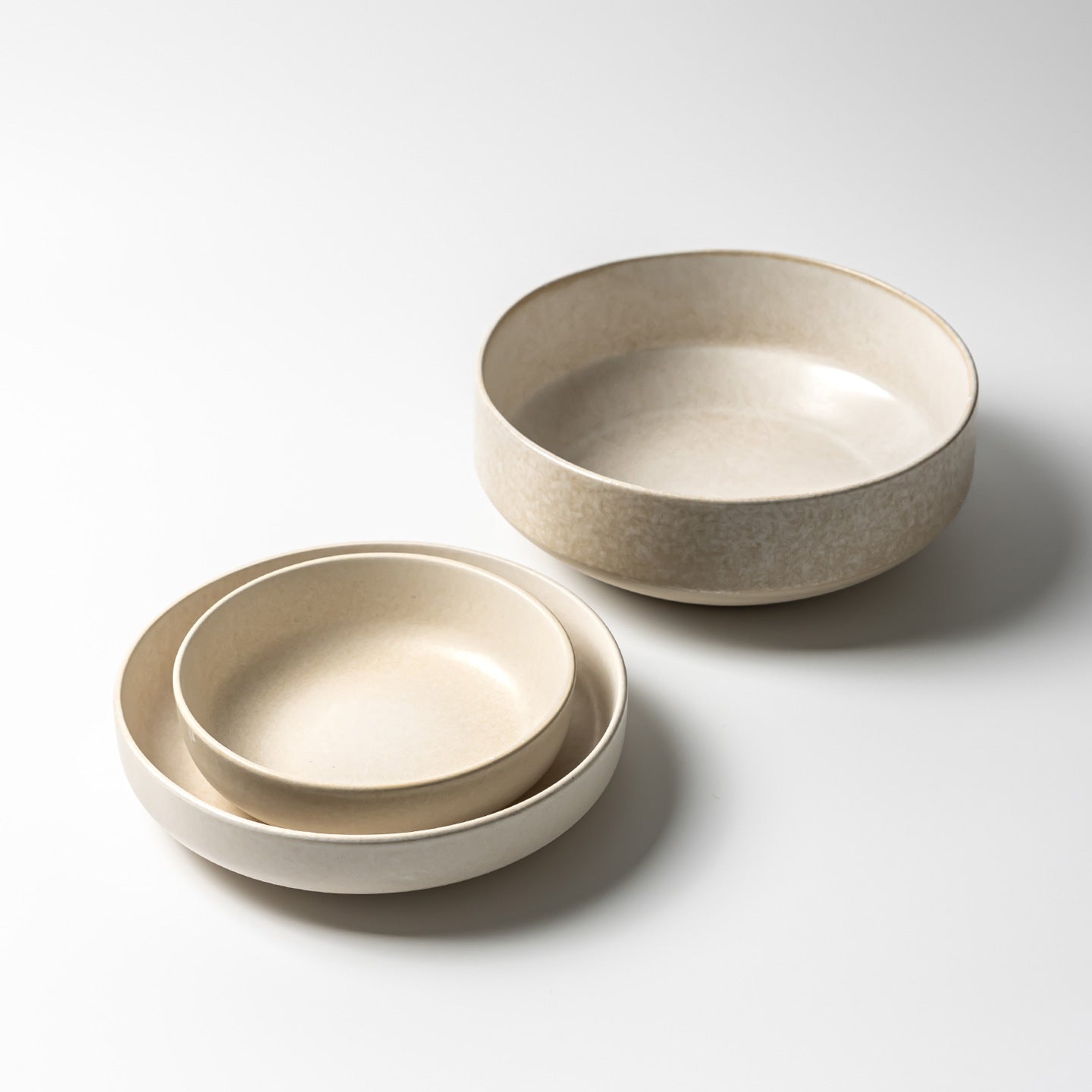 Stacked Japanese retro ceramic plates in frost flower white glaze, displaying round shape and minimalist solid color design.