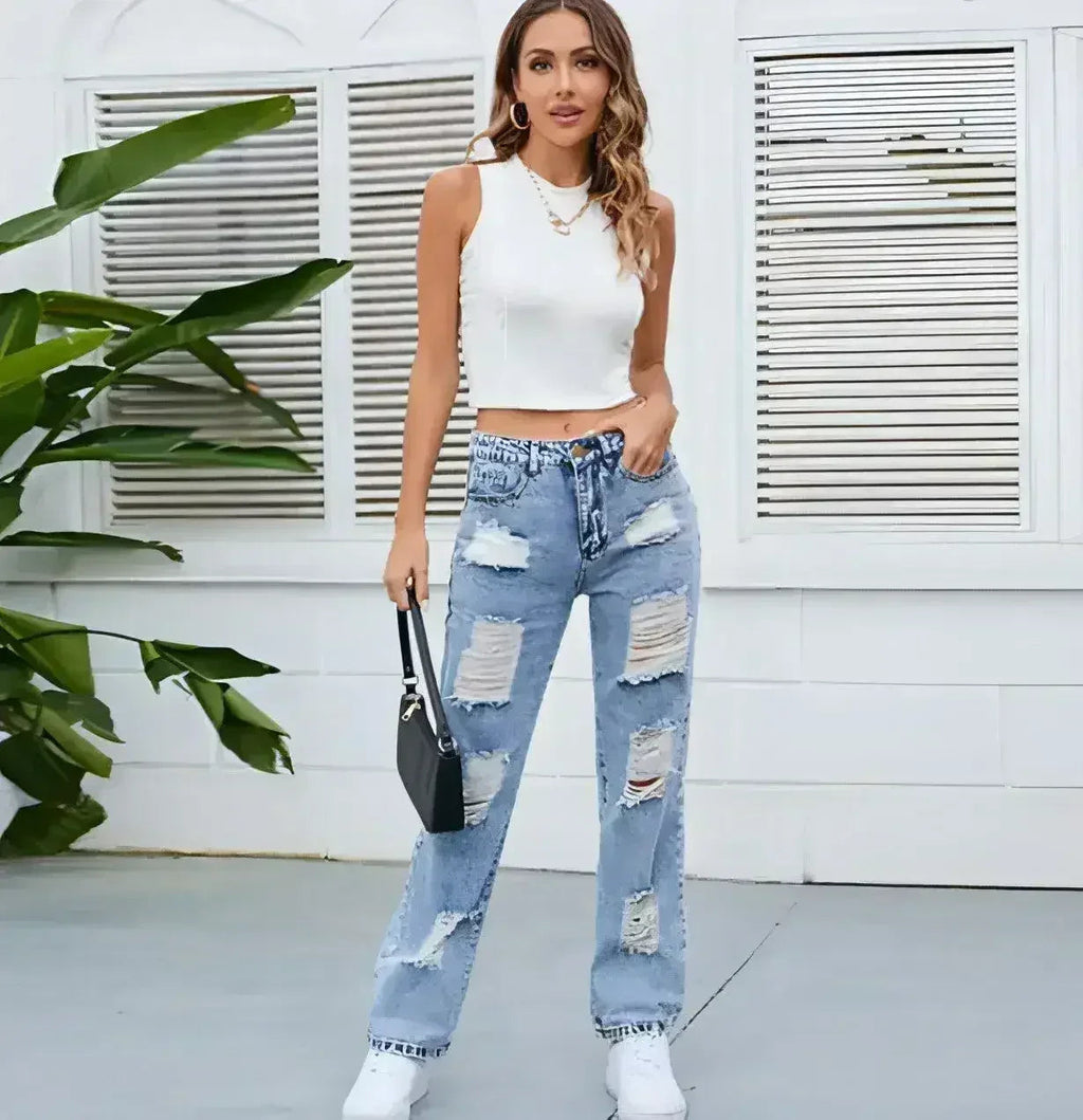 Women’s light blue distressed straight-leg jeans paired with white crop top, side angle full body view